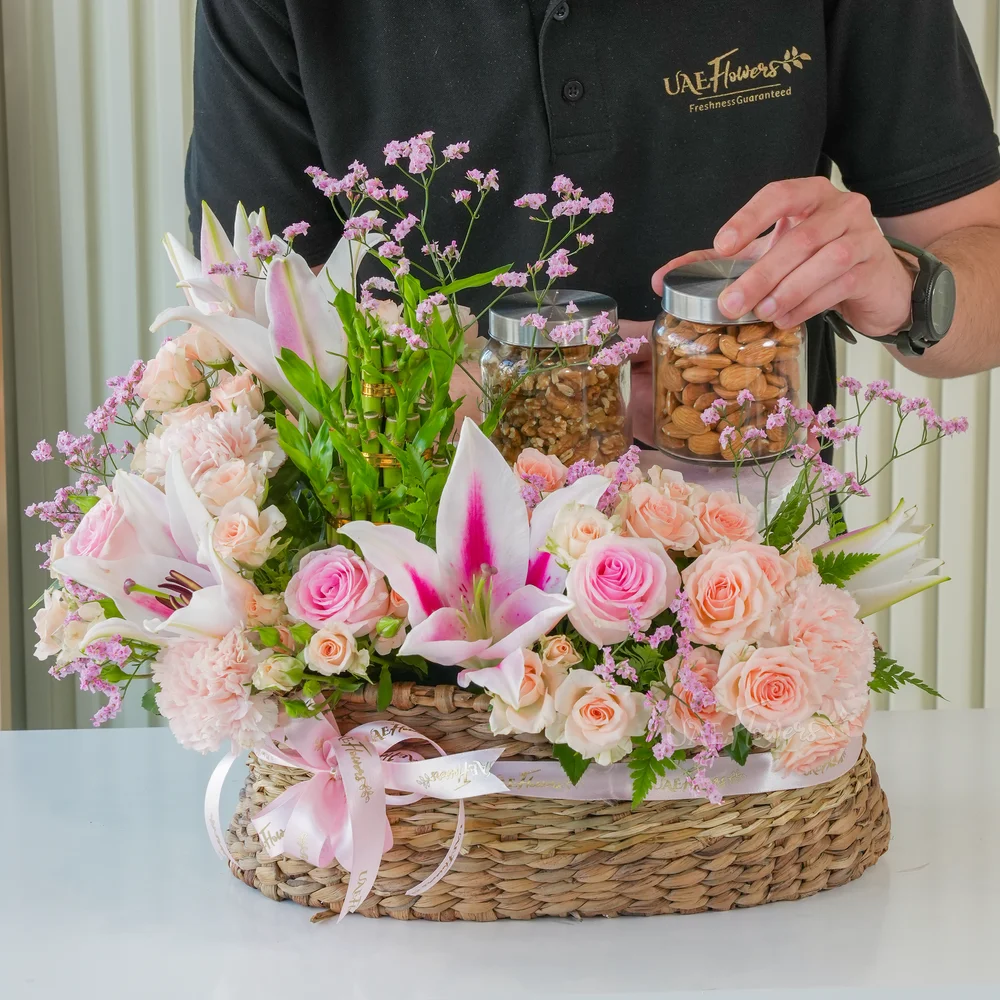 A basket arrangement of 250 Gms of Almonds, 250 Gms of walnut, 3 layer lucky bamboo, 2 pink lilies, 3 pink carnations, 5 pink roses and 4 pink spray roses with limonium fillers.