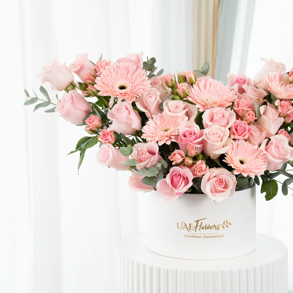 A box arrangement of 5 pink gerberas, 20 pink roses and 3 pink spray roses with green fillers.