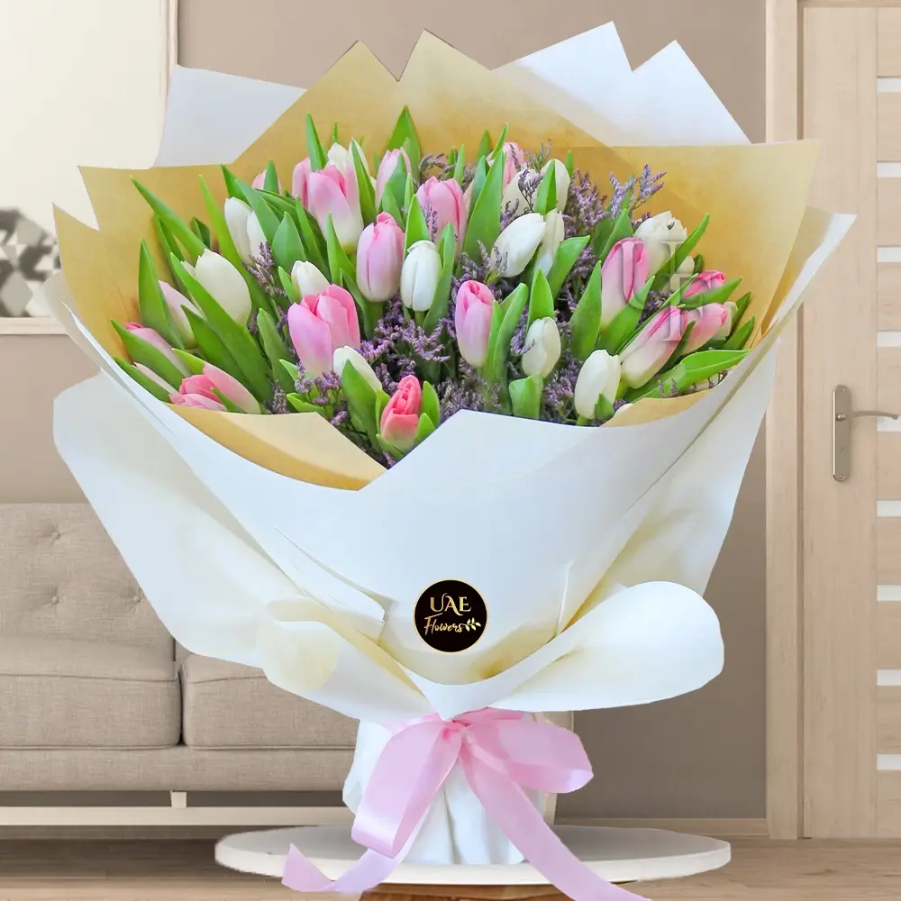 A bouquet of 15 pink & 15 white tulips with fillers in a white and yellow wrapping paper tied with pink ribbon