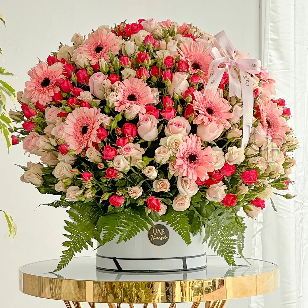 20 pink gerberas, 20 pink roses, 20 pink spray roses, and 20 peach spray roses with green fillers and eucalyptus leaf in a white round box.
