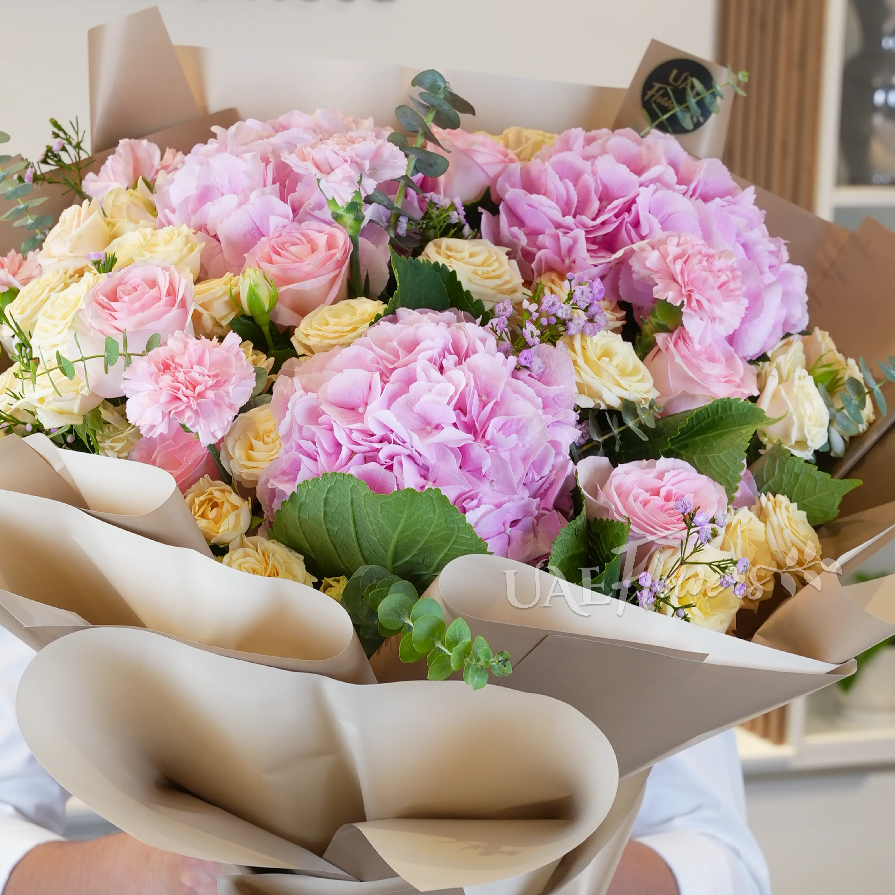 bouquet of 3 pink hydrangeas, 6 pink carnations, 6 pink roses, and 5 peach spray roses