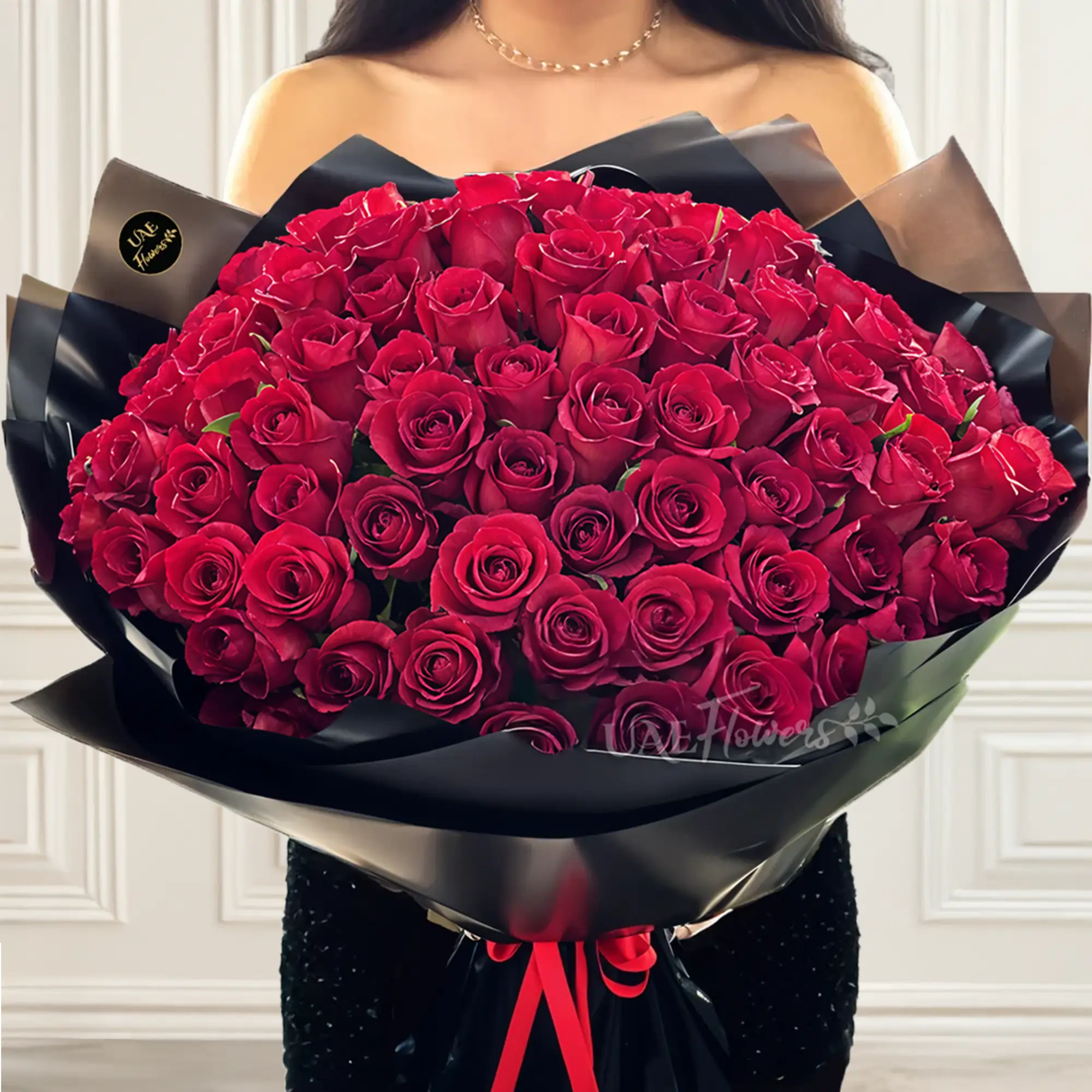 A romantic bouquet of 100 red roses in black wrapping paper tied with black ribbon