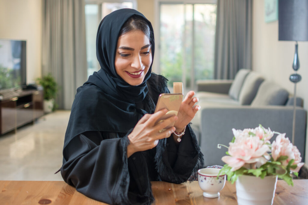 A Woman Wearing Abayas Using a Phone